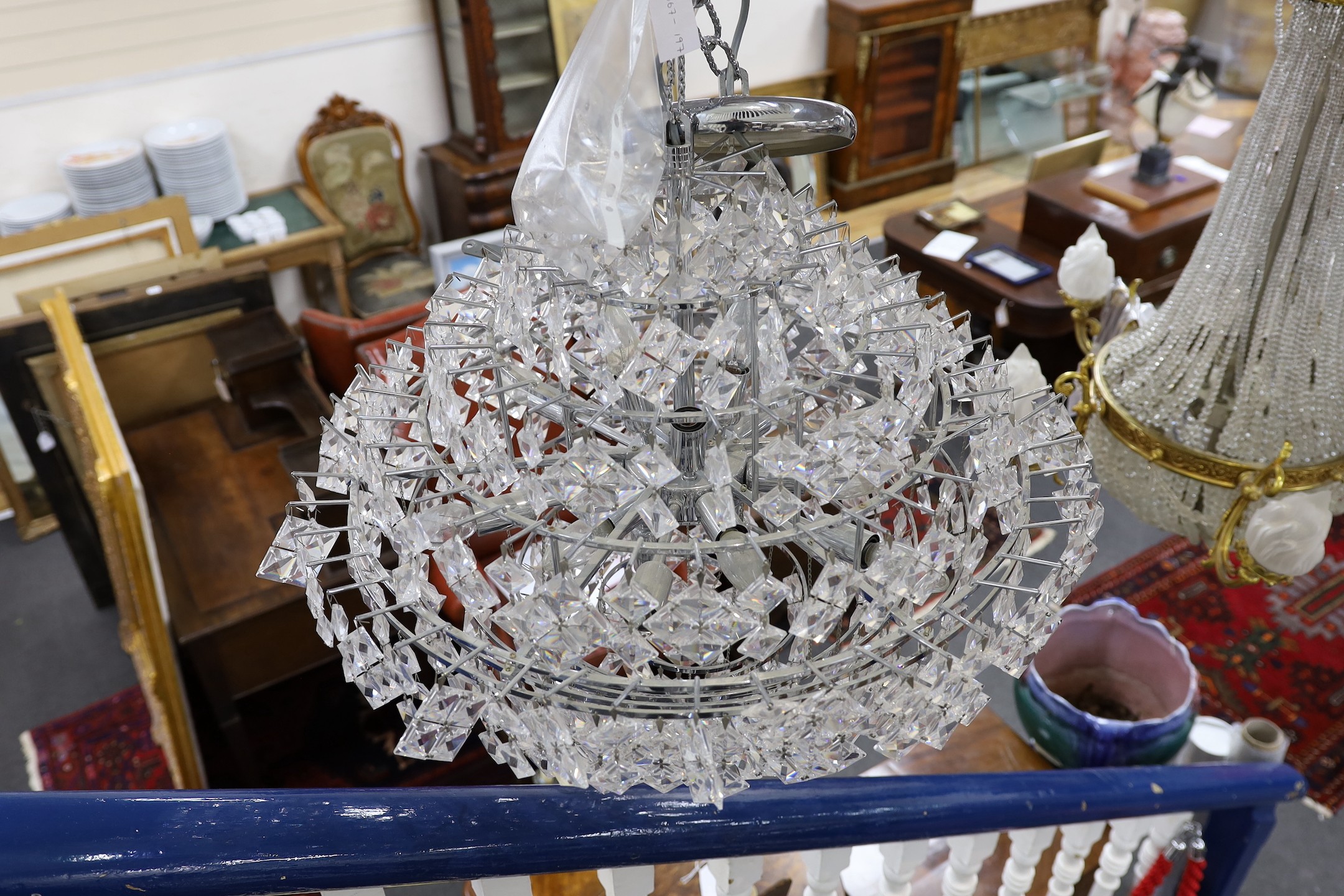 A ten tier, eighteen light, graduated chrome chandelier, with diamond shaped clear perspex drops